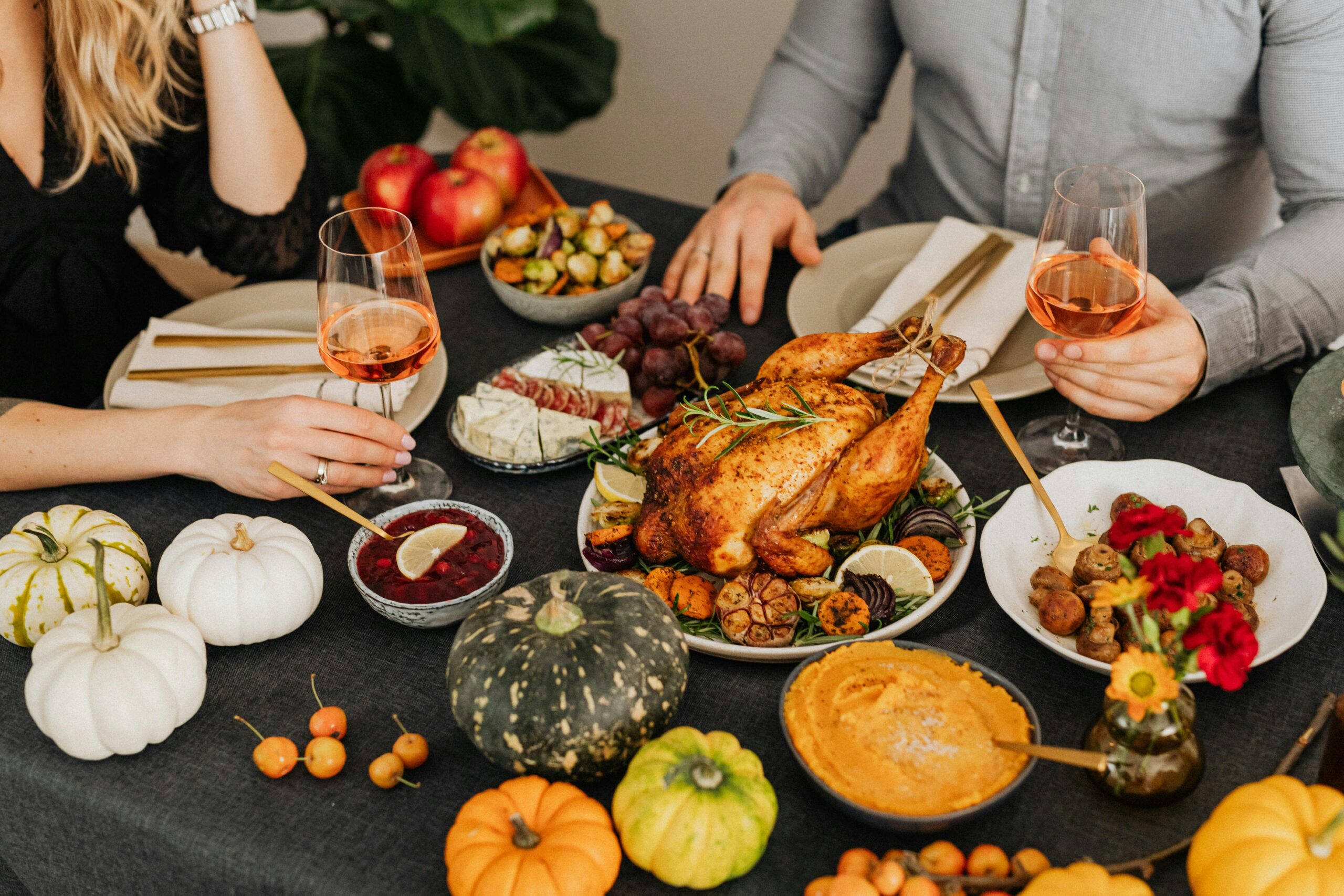 A warm and inviting Thanksgiving dinner setup featuring turkey, wine, and autumn vegetables.